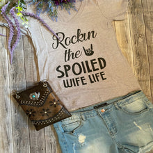 Load image into Gallery viewer, Grey tank top with 'Rockin the Spoiled Wife Life' text, paired with denim shorts and a brown purse on a wooden surface.